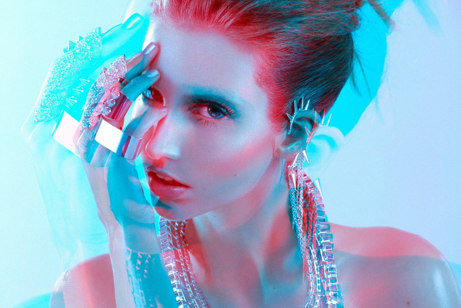 Nude make-up accentuates the beauty of model Adeline Petit with her jewels in an artistic electric blue and red image by photographer Etienne Delorme, featured in Faust Magazine.